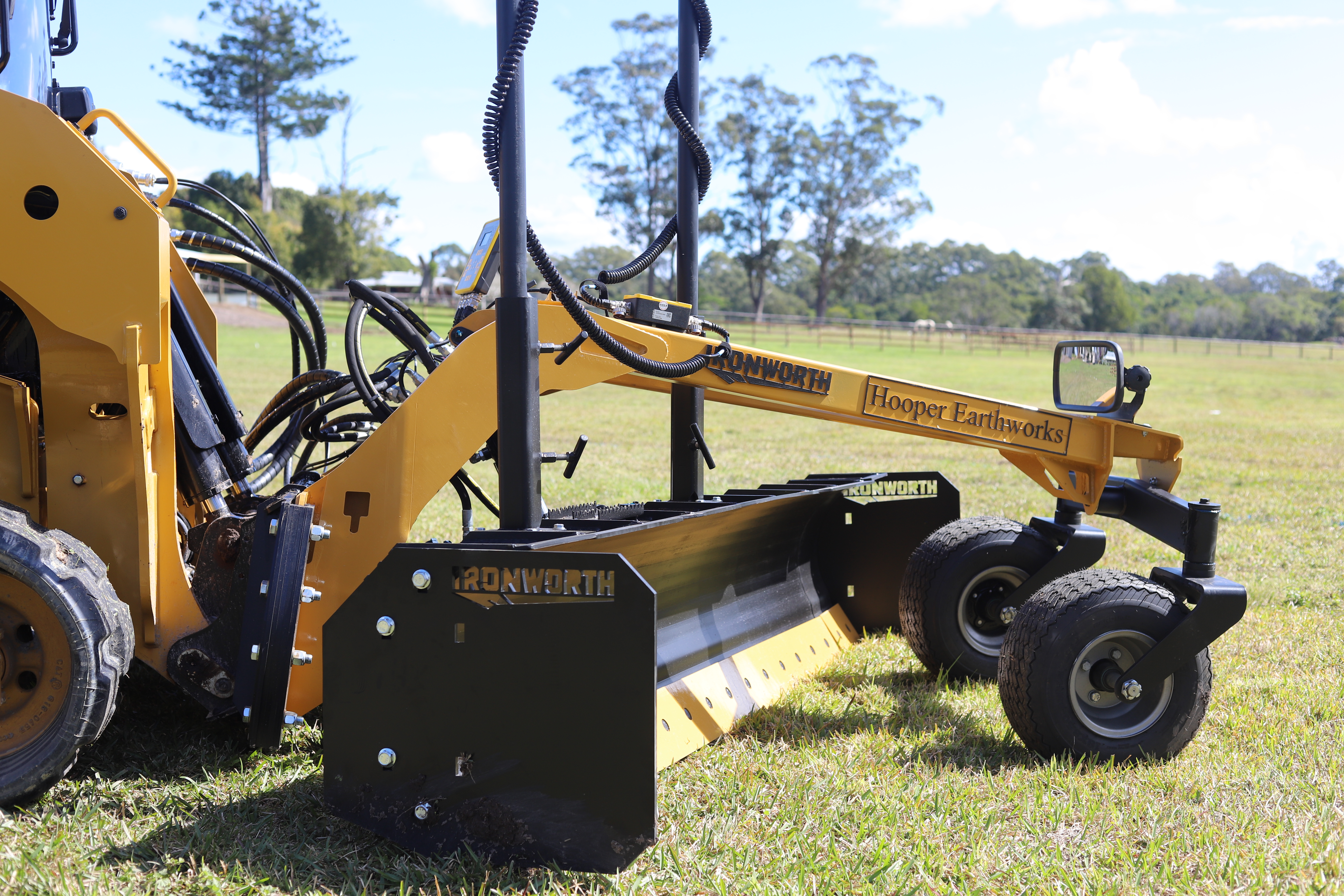 Ironworth grader blade with laser receiver on a skid-steer at a residential site
