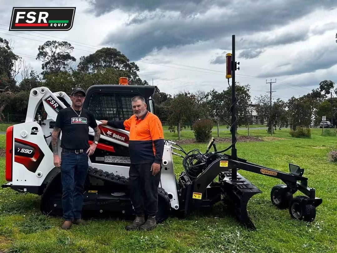 Barry Payne standing beside his Ironworth grader blade and laser mast fitted to a Bobcat compact track loader on a property at Mount Gambier