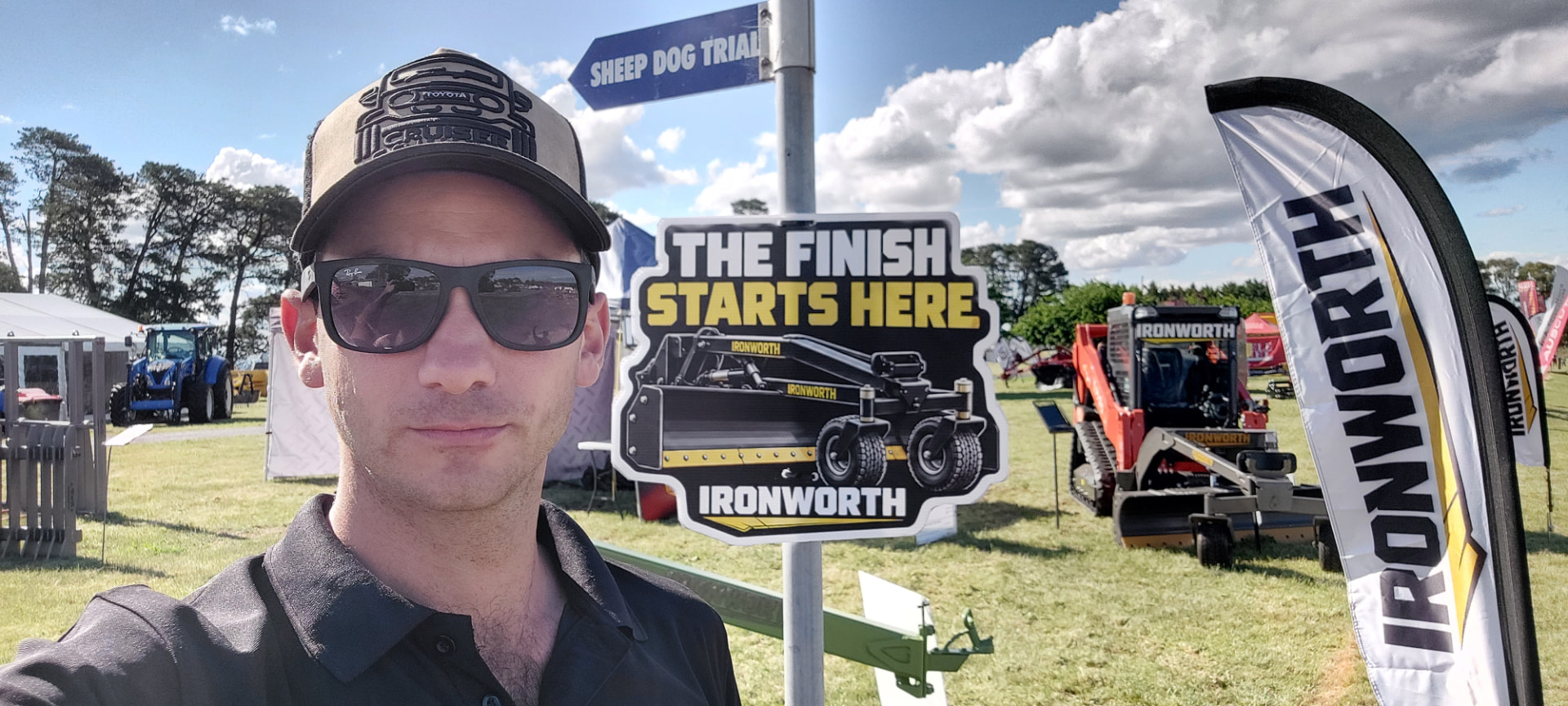 Brad Litchfield standing beside the Ironworth display and a PAT-Grader at an agricultural field day
